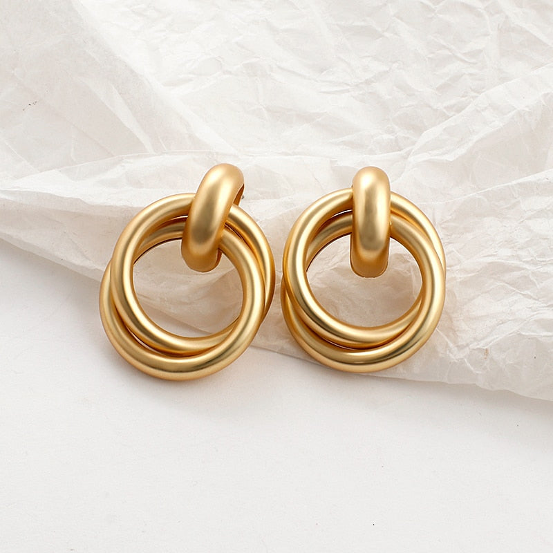 Pearl and alloy geometric earrings worn close-up