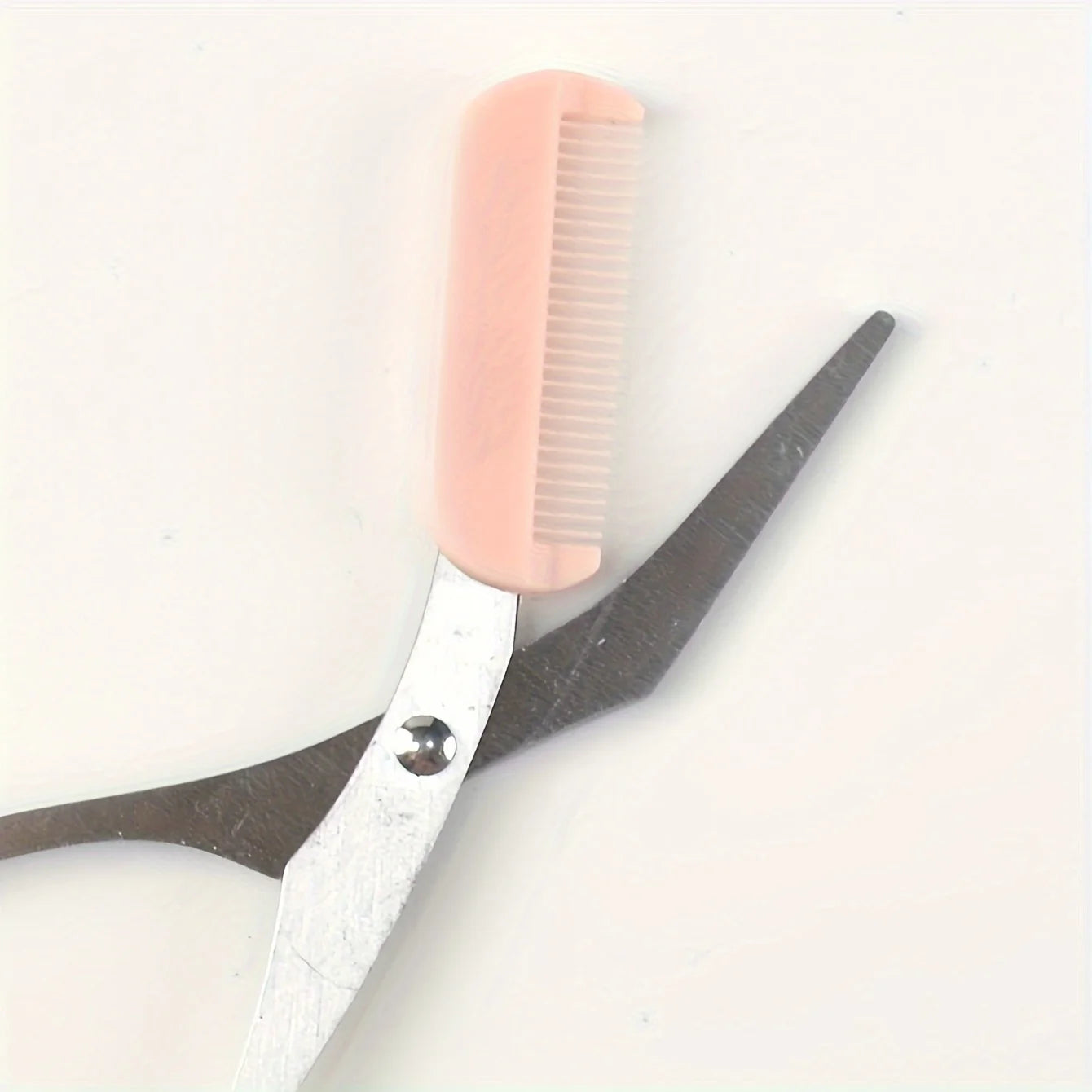 Pink stainless steel eyebrow trimming scissors with built-in comb, precise grooming tool for perfect eyebrows by Prime Deal Zone.