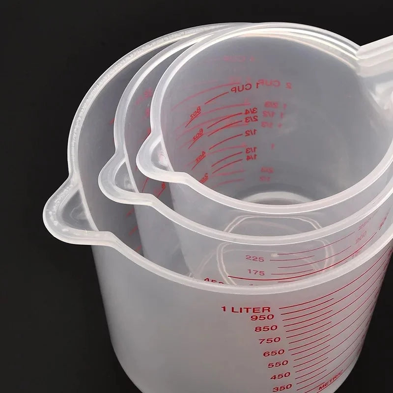 Set of three Prime Deal Zone plastic baking measuring cups with PVC volume scales, including 250ml, 500ml, and 1000ml beakers.
