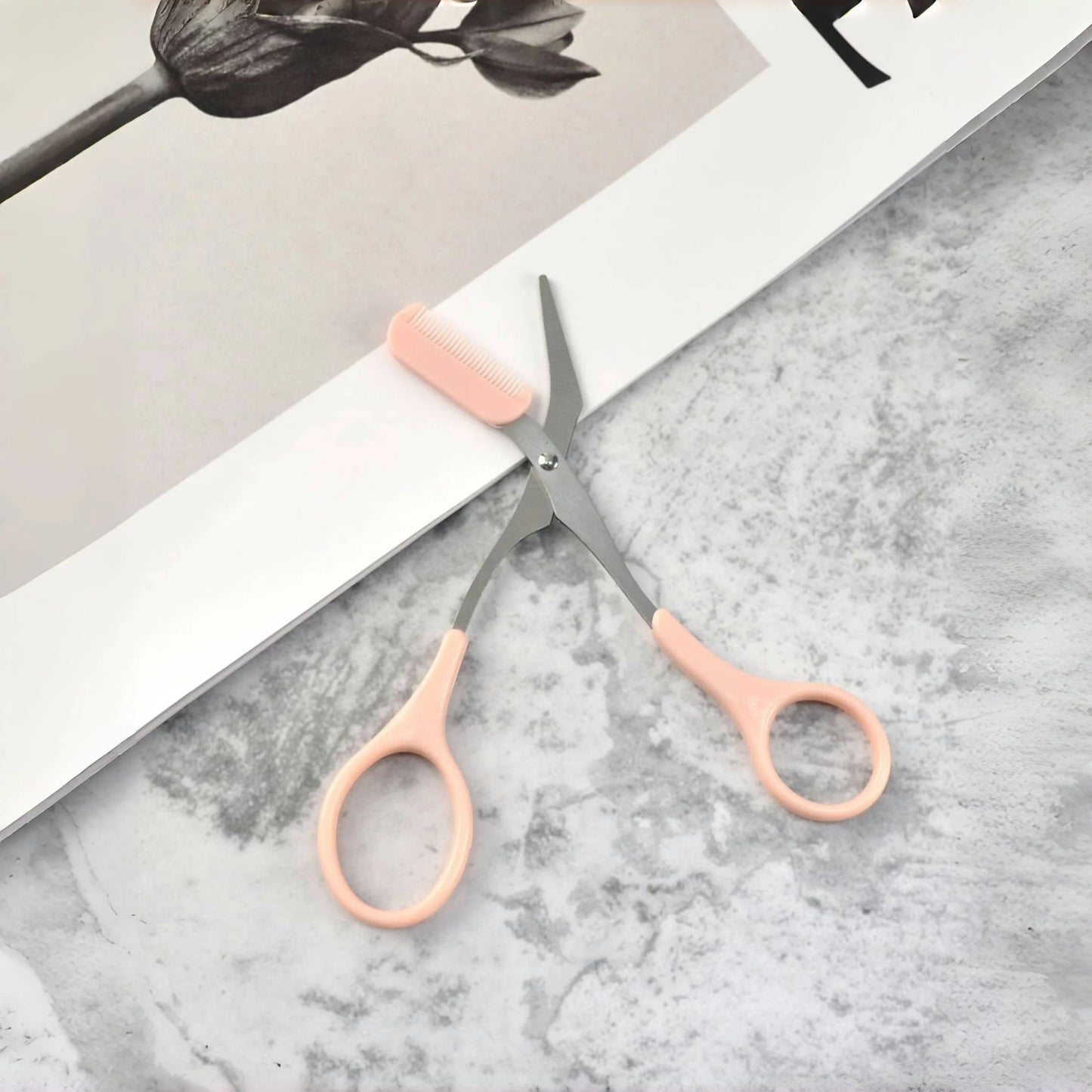 Pink stainless steel eyebrow trimming scissors with built-in comb by Prime Deal Zone, ideal for precise eyebrow grooming.