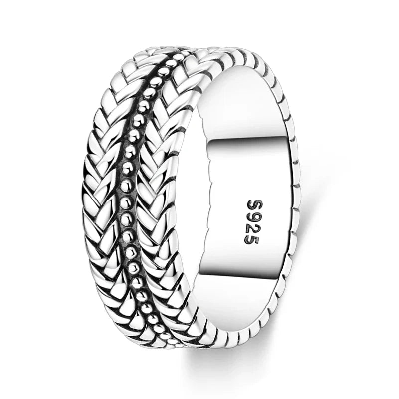 Silver X ring worn stacked with other rings