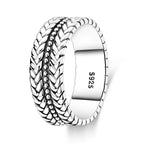 Silver X ring worn stacked with other rings