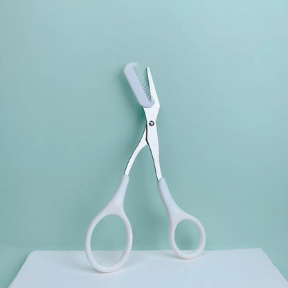 Pink eyebrow trimming scissors with built-in comb from Prime Deal Zone, stainless steel grooming tool for precise eyebrow shaping.