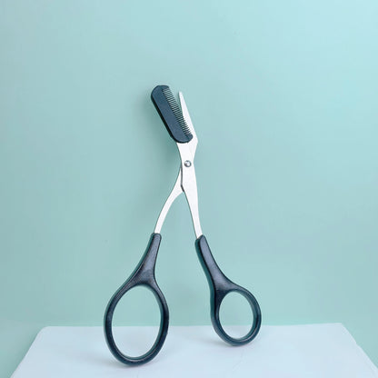 Pink stainless steel eyebrow trimming scissors with built-in comb, precise grooming tool for shaping perfect eyebrows.