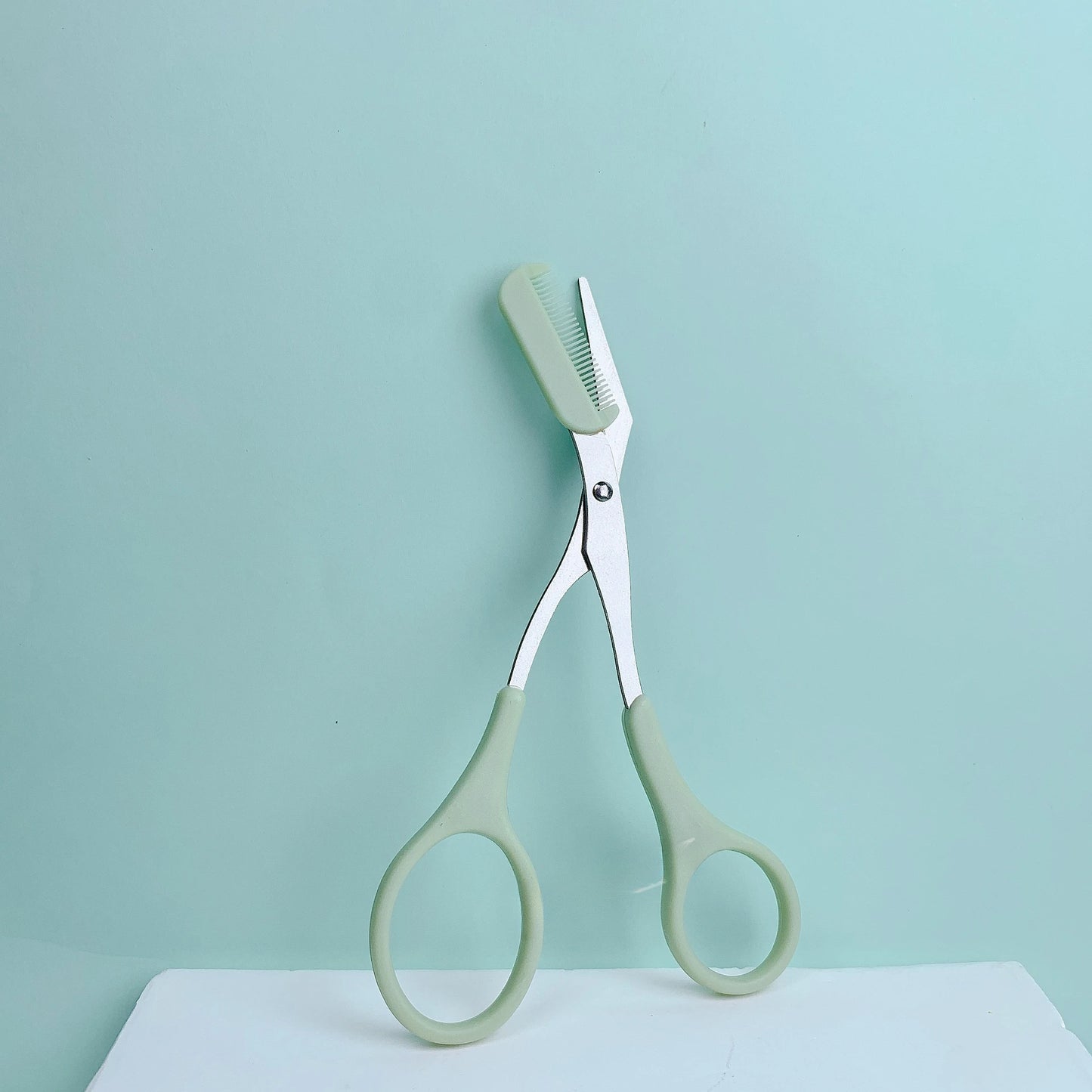 Pink stainless steel eyebrow trimming scissors with built-in comb from Prime Deal Zone for precise grooming and perfect eyebrows.