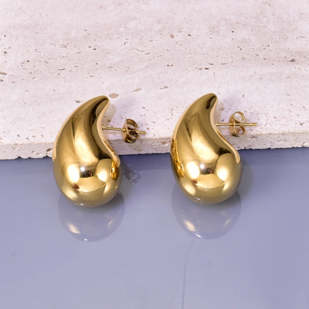 Gold hollow drop earrings for women, pair on display