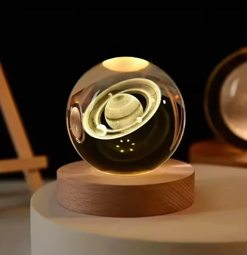 Transparent glass crystal ball featuring 3D Saturn, moon, and planets design for home decor and celestial-themed decoration.